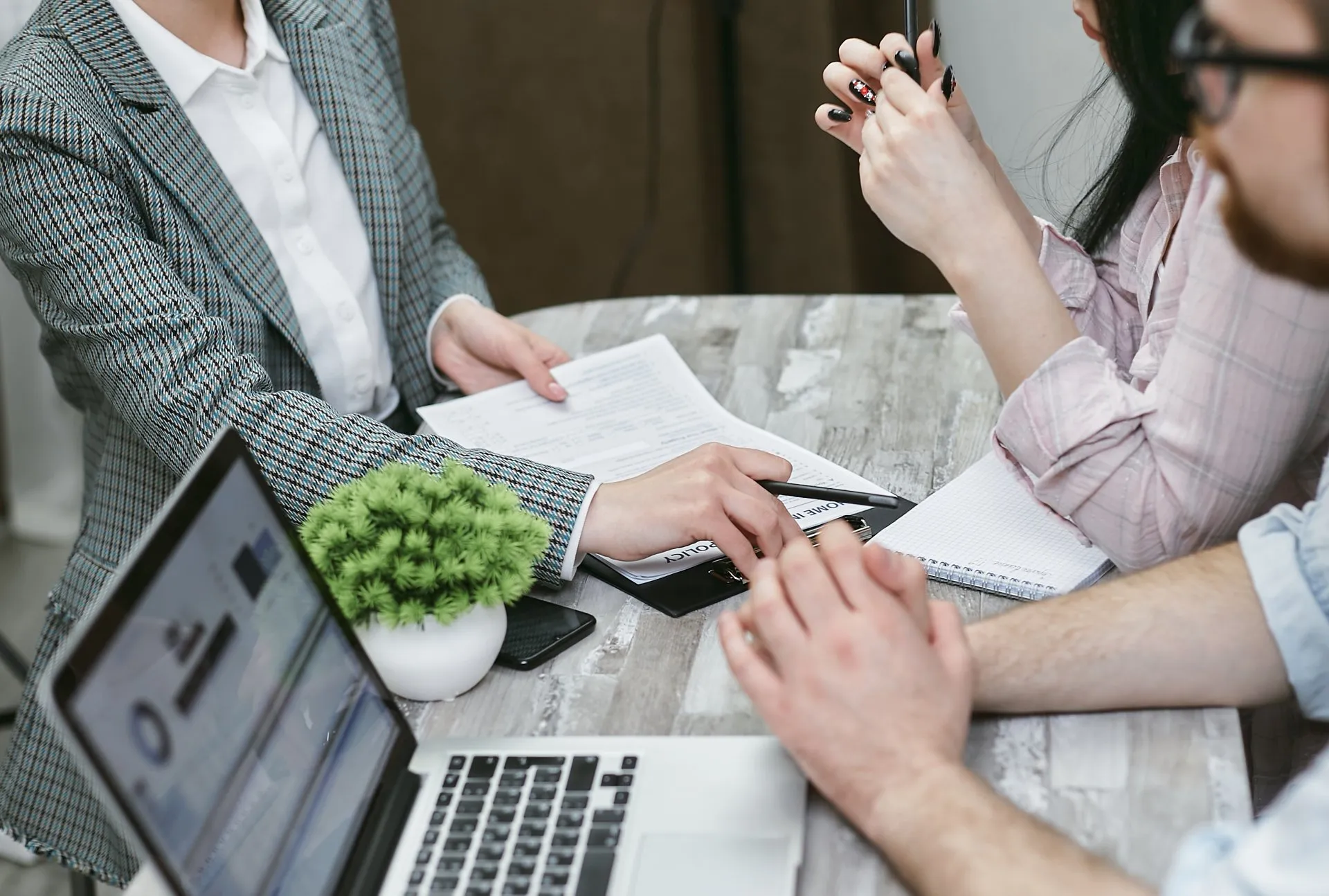 A brokerage firm dispute lawyer reviewing legal documents with a couple during a consultation.