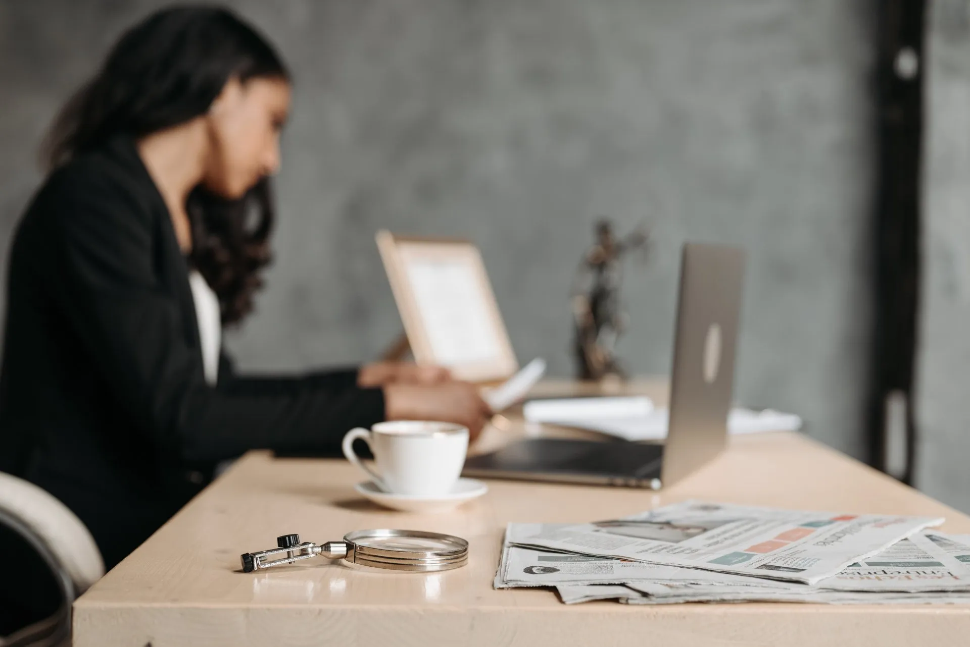 A financial professional at a desk with a magnifying glass, symbolizing investigation of trust company violations.