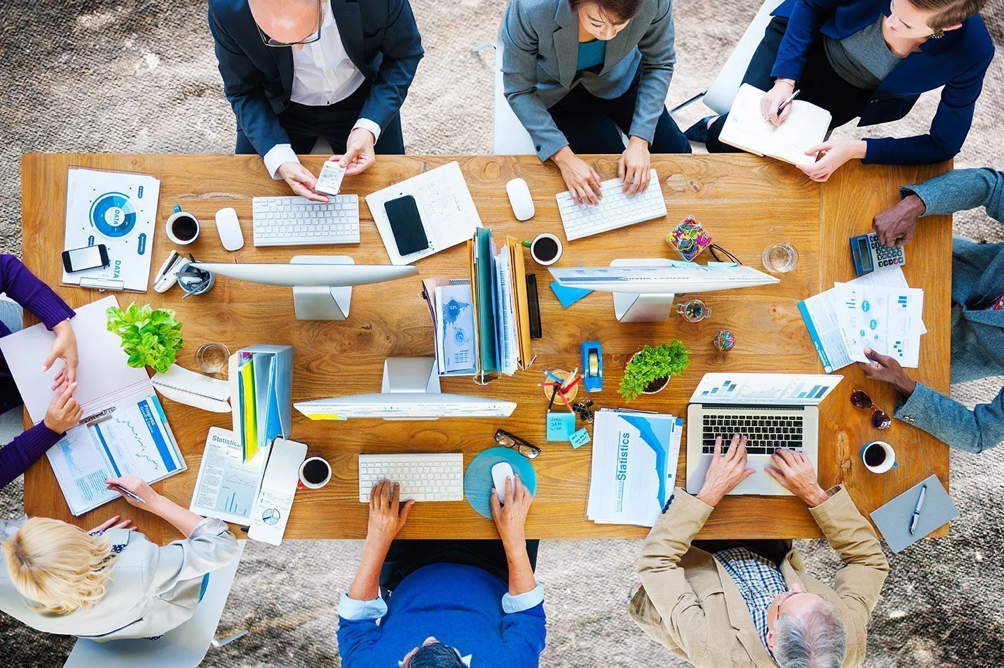 A group works at a table with devices, symbolizing the illegal practice of selling away.