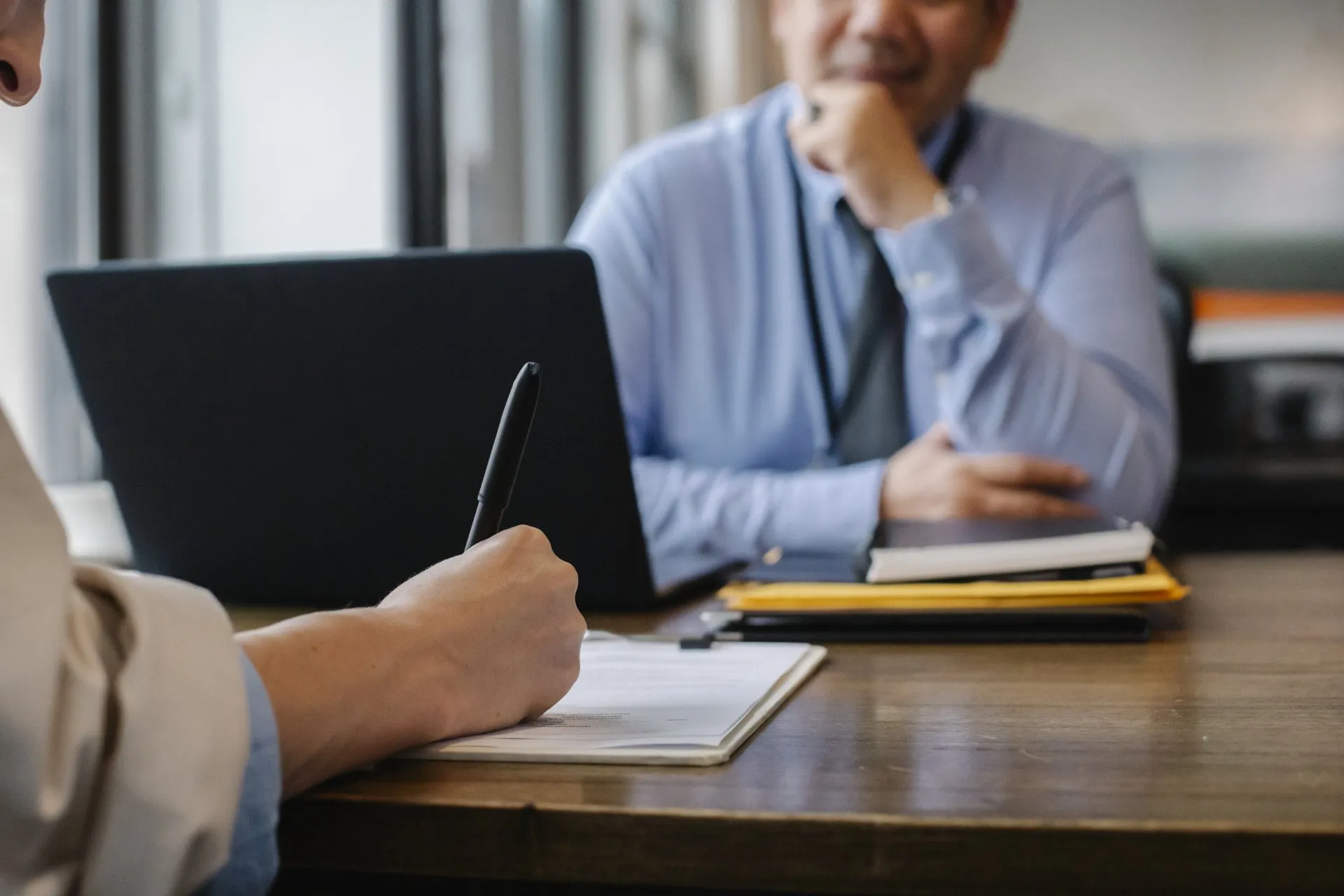 A lawyer or financial advisor discussing documents with clients, representing brokerage firm disputes.