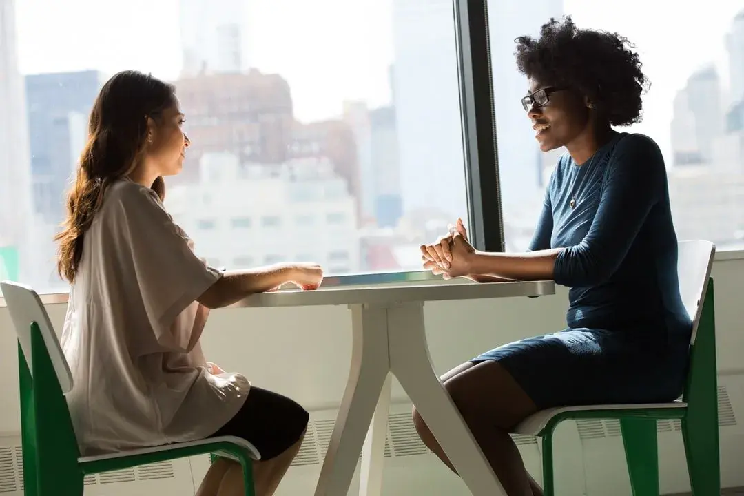 Two women having a professional conversation, representing a financial consultation about securities and safeguarding.