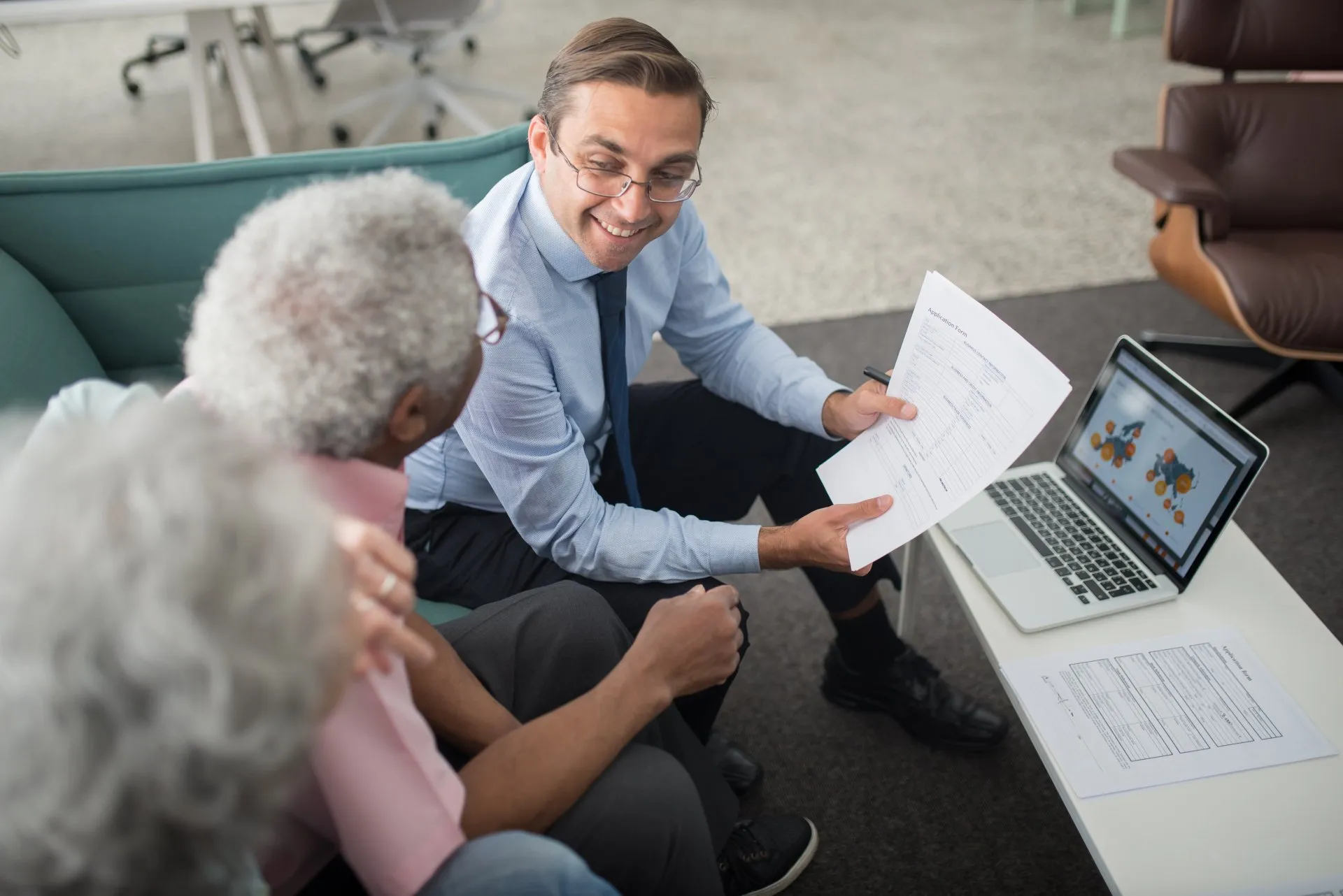 A financial advisor discusses documents with an older couple about complex investment litigation.